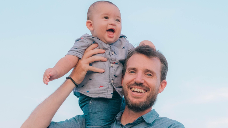 Far holder baby på skulder